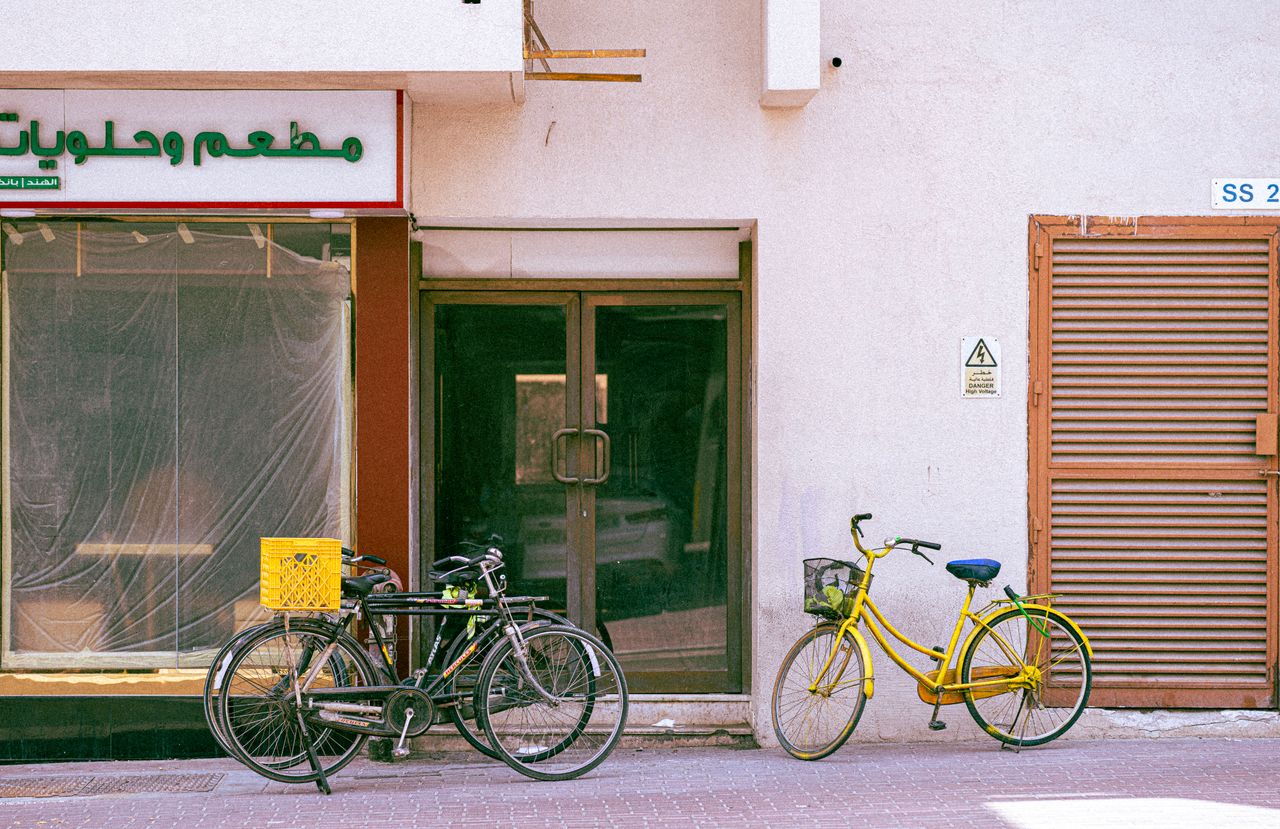 Vibrant bicycles parked outside a Dubai storefront on a sunny day.